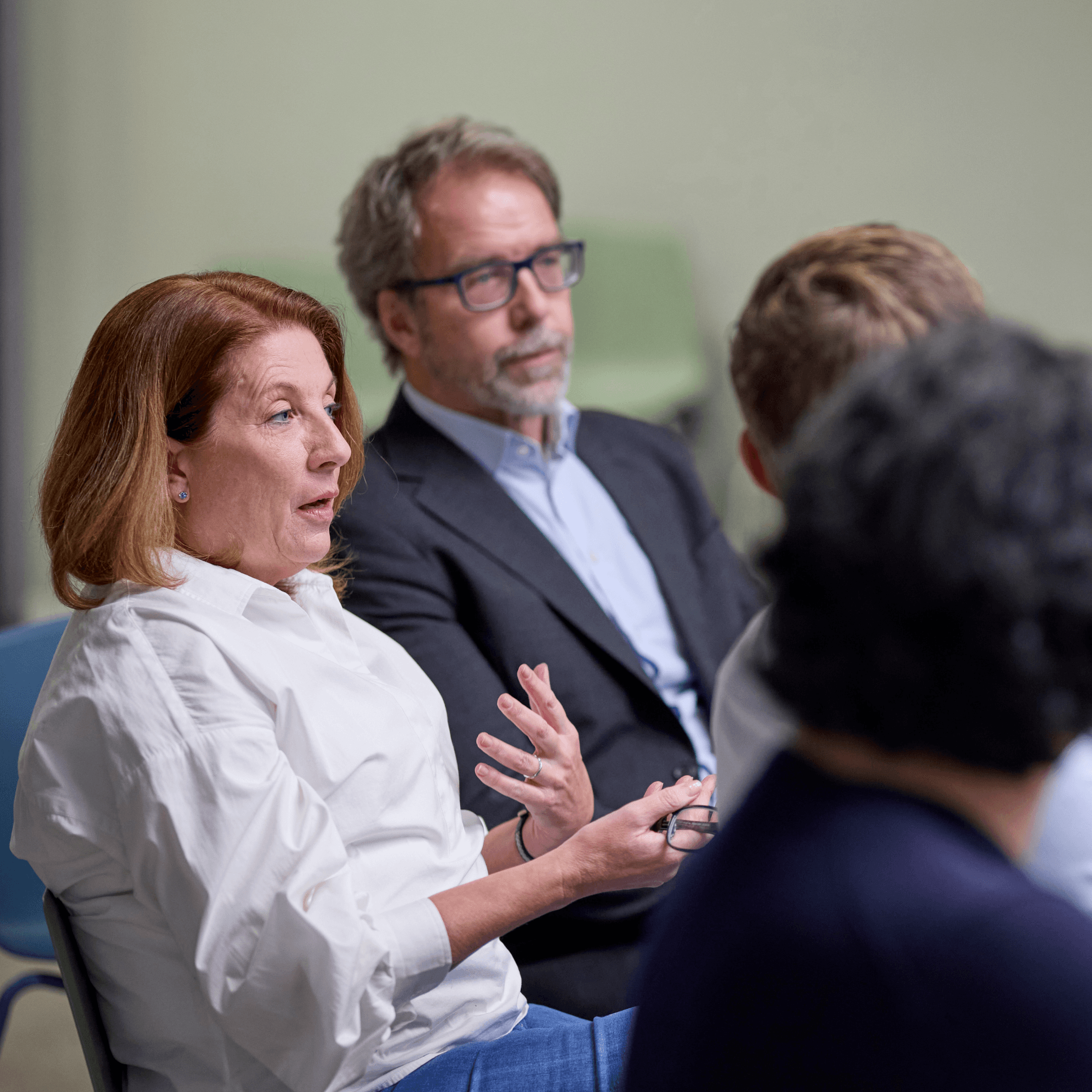 Woman speaking in a group discussion while others listen around her
