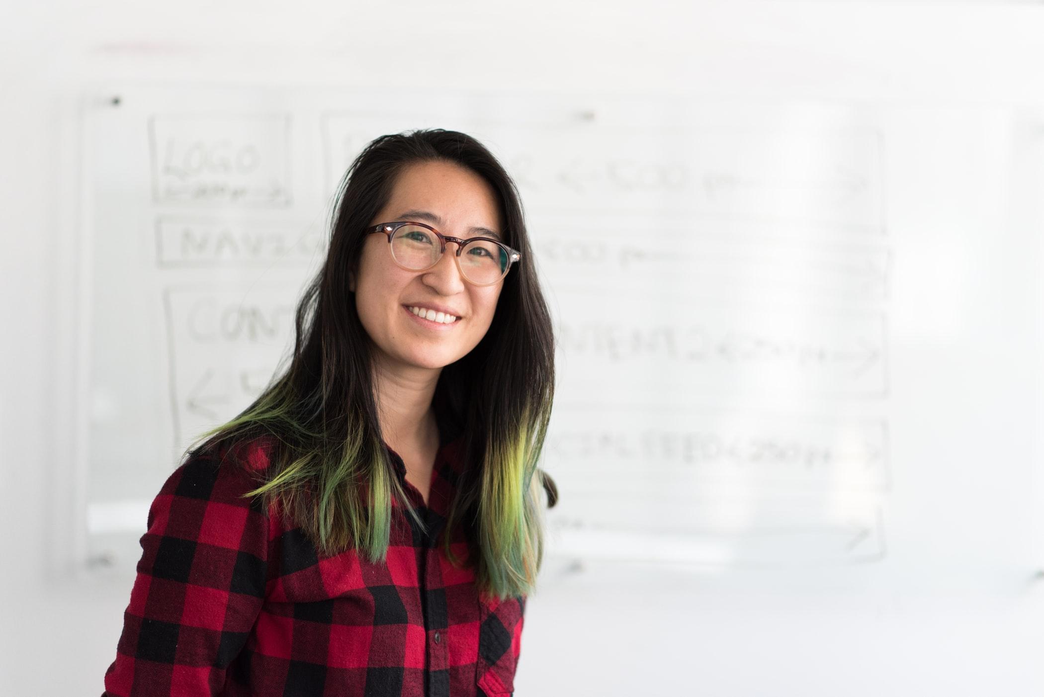female teacher standing in front on a whiteboard 
