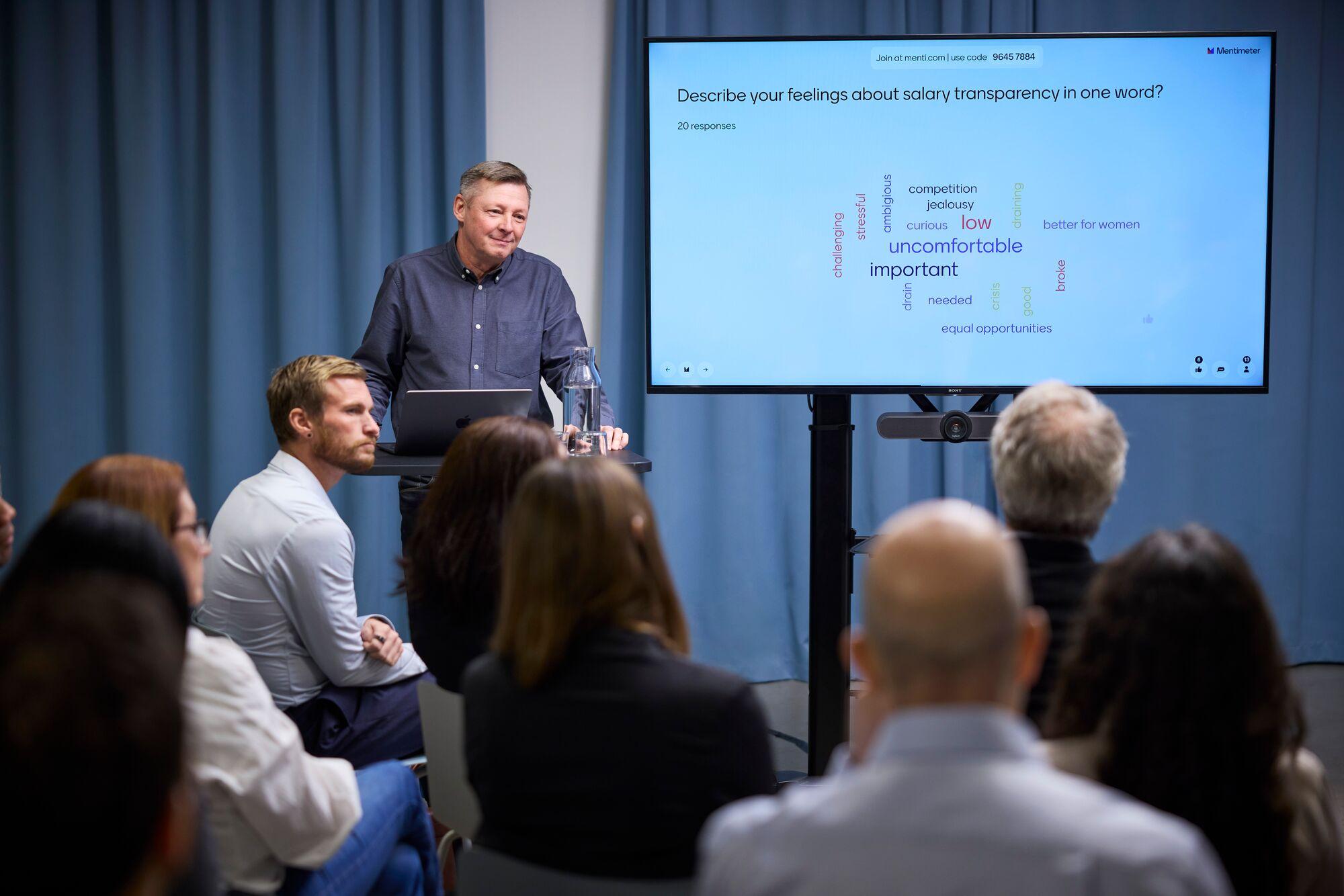 Speaker presenting on salary transparency using Mentimeter