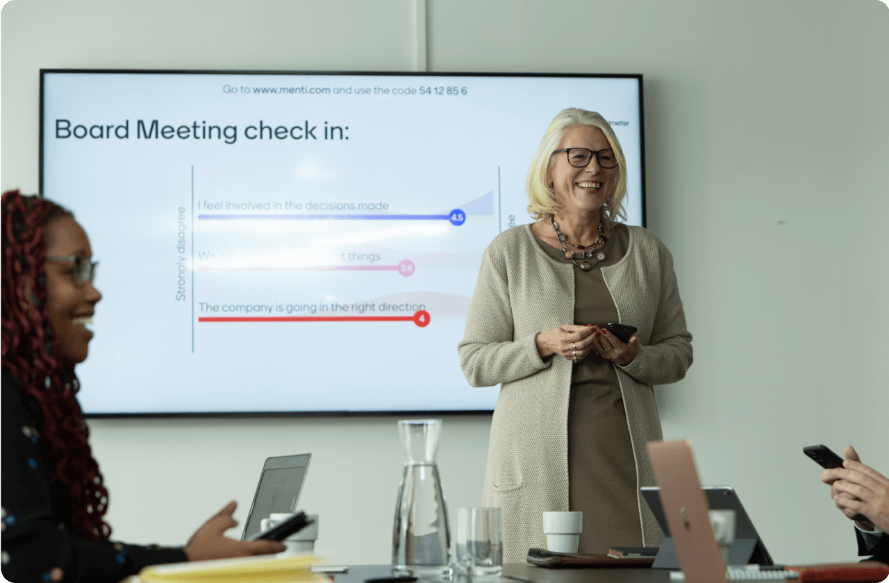 Woman presenting a board meeting check in using Mentimeter.